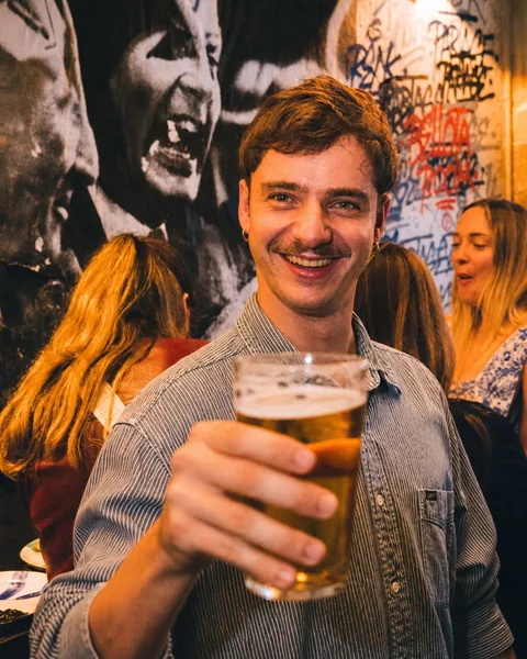 Homme souriant avec une bière au bar